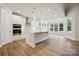 Modern, open-concept kitchen with white cabinets, island, stainless steel appliances and hardwood floors at 104 Brooke Forest Ct, Mooresville, NC 28115