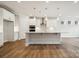 Bright, open-concept kitchen with island, pendant lighting, stainless steel appliances, and hardwood floors at 104 Brooke Forest Ct, Mooresville, NC 28115