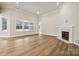 Bright, spacious living room with hardwood floors, neutral walls, a fireplace, and ample natural light at 104 Brooke Forest Ct, Mooresville, NC 28115