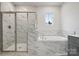 Spa-like bathroom with soaking tub, shower, and marble tile at 108 Brooke Forest Ct, Mooresville, NC 28115