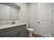 Modern bathroom with gray vanity, white toilet, and a large mirror at 108 Brooke Forest Ct, Mooresville, NC 28115