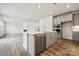 Open concept kitchen with island, stainless steel appliances, and hardwood floors at 108 Brooke Forest Ct, Mooresville, NC 28115