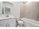 Bright bathroom featuring a modern vanity, tile flooring, and a bathtub with tiled walls at 232 E Warfield Dr, Mooresville, NC 28115