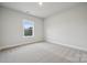 A clean bedroom with carpet, a window with a wooded view, and ample natural light at 232 E Warfield Dr, Mooresville, NC 28115