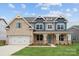 New two-story home boasts a brick facade, blue accents, an attached two-car garage, and a well-manicured front lawn at 232 E Warfield Dr, Mooresville, NC 28115