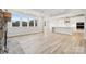 Open living space with a stone fireplace, hardwood floors, coffered ceilings, and a view into the modern kitchen at 232 E Warfield Dr, Mooresville, NC 28115