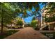 Evening view of charming community entrance with brick pavers, string lights, and lush landscaping at 607 Mattie Rose Ln, Charlotte, NC 28204