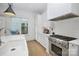 Modern white kitchen with farmhouse sink and stainless steel appliances at 607 Mattie Rose Ln, Charlotte, NC 28204