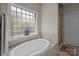 Bathroom with soaking tub, shower, and a window at 1302 Devonmere Pl, Salisbury, NC 28144