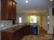 Kitchen features dark wood cabinets, granite countertops, and a breakfast bar at 1302 Devonmere Pl, Salisbury, NC 28144