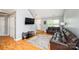 Living room with hardwood floors, brown leather couch, and a view of the entryway at 4816 Windchase Ln, Charlotte, NC 28269