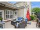 Cozy patio with wicker furniture, fire pit, and red umbrella, perfect for outdoor relaxation at 3203 Kelsey Plz, Kannapolis, NC 28081