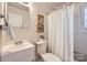 Cozy bathroom featuring a shower with white curtain, a toilet and a clean, modern sink at 3210 Marlborough Rd, Charlotte, NC 28208