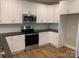 Modern kitchen featuring white cabinets, stainless steel appliances, and dark countertops at 118 Abbington Ln, Shelby, NC 28150