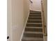 Carpeted staircase with wood railing leading to upper level at 120 Abbington Ln, Shelby, NC 28150