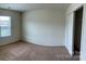A bright bedroom with neutral walls and carpet features a closet and natural light from the window at 1009 Dawn Light Rd, Indian Trail, NC 28079