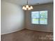 Bright dining area featuring a modern chandelier, a large window, and neutral carpet at 1009 Dawn Light Rd, Indian Trail, NC 28079