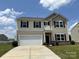 Charming two-story home with a two-car garage, landscaped yard, and classic architectural details at 1009 Dawn Light Rd, Indian Trail, NC 28079