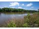 Scenic lake view surrounded by lush greenery, with calm waters reflecting the sky at 127 Palos Verde Rd, Mooresville, NC 28117