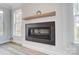 Modern fireplace with a sleek black surround, a wooden mantel, and natural light streaming in from nearby windows at 1770 Post Ct # Lot 510, Gastonia, NC 28054