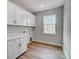 Well-lit laundry room with cabinets and wood-look flooring at 1770 Post Ct # Lot 510, Gastonia, NC 28054