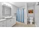 Bright bathroom featuring a large vanity mirror, sink, toilet and shower/tub combination at 122 Long Cove Ln, Mooresville, NC 28117