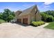 Spacious three-car garage with an expansive driveway and lush, mature landscaping at 122 Long Cove Ln, Mooresville, NC 28117