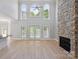 Large living room featuring tall windows, fireplace and hardwood floors at 122 Long Cove Ln, Mooresville, NC 28117