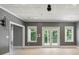 Bright living room with white trim and gray walls, large windows and double doors at 122 Long Cove Ln, Mooresville, NC 28117