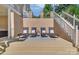 Outdoor patio with stone wall, stairs, a dark-colored outdoor rug, and four lounge chairs at 122 Long Cove Ln, Mooresville, NC 28117