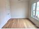 Bright bedroom featuring hardwood floors, a large window with neighborhood views, and a double-door closet at 13217 Terrace Court Dr, Charlotte, NC 28278