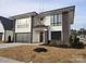 Modern two-story home with stone accents and a gray metal garage door at 13217 Terrace Court Dr, Charlotte, NC 28278
