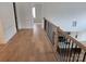 Second-floor hallway with wood floors and black metal railing at 13217 Terrace Court Dr, Charlotte, NC 28278