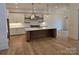 Modern kitchen with white cabinets, large island, and hardwood floors at 13217 Terrace Court Dr, Charlotte, NC 28278