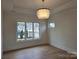 Bright room with an elegant chandelier, hardwood floors, and large windows overlooking the neighborhood at 13217 Terrace Court Dr, Charlotte, NC 28278