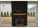 Stone outdoor fireplace on covered patio with backyard view at 13217 Terrace Court Dr, Charlotte, NC 28278