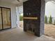 Outdoor patio featuring a stone fireplace, concrete flooring, and a view of the backyard at 13217 Terrace Court Dr, Charlotte, NC 28278