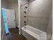 Bright bathroom features a tub with shower and gray tiled shower at 2027 Cedar Falls Dr # 75, Waxhaw, NC 28173