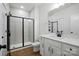 Bright bathroom with glass shower, white vanity with black fixtures, and wood floor at 2027 Cedar Falls Dr # 75, Waxhaw, NC 28173
