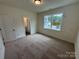 A sunlit bedroom showcases neutral carpet and trim with an inviting window view at 2027 Cedar Falls Dr # 75, Waxhaw, NC 28173