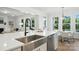 Open-concept kitchen featuring an island with stainless steel sink, breakfast bar and modern fixtures at 2027 Cedar Falls Dr # 75, Waxhaw, NC 28173