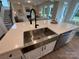 Kitchen island featuring a stainless farmhouse sink, quartz countertop, and seating for casual dining at 2027 Cedar Falls Dr # 75, Waxhaw, NC 28173