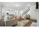Open-concept living room with staircase, flowing into the kitchen and dining area at 2027 Cedar Falls Dr # 75, Waxhaw, NC 28173