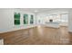 Open concept living room with a kitchen island, hardwood floors, and large windows at 2027 Cedar Falls Dr # 75, Waxhaw, NC 28173