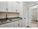 Well-lit mud room with utility sink, gray countertops, white cabinetry and closet at 2027 Cedar Falls Dr # 75, Waxhaw, NC 28173