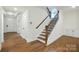 Bright foyer with hardwood floors, staircase with wood handrail and white trim at 2027 Cedar Falls Dr # 75, Waxhaw, NC 28173