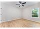 Neutral bedroom with a ceiling fan, a window view, and wood-look flooring at 1011 Indiana St, Kannapolis, NC 28083