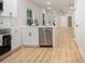 Open concept kitchen with stainless steel dishwasher, white cabinets, and wood-look flooring at 1011 Indiana St, Kannapolis, NC 28083