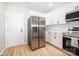 Kitchen with stainless steel appliances, white cabinets, and wood-look flooring at 1011 Indiana St, Kannapolis, NC 28083