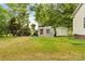 Backyard features grassy lawn, metal carport, shed, and mature trees at 3951 Springs Rd, Conover, NC 28613